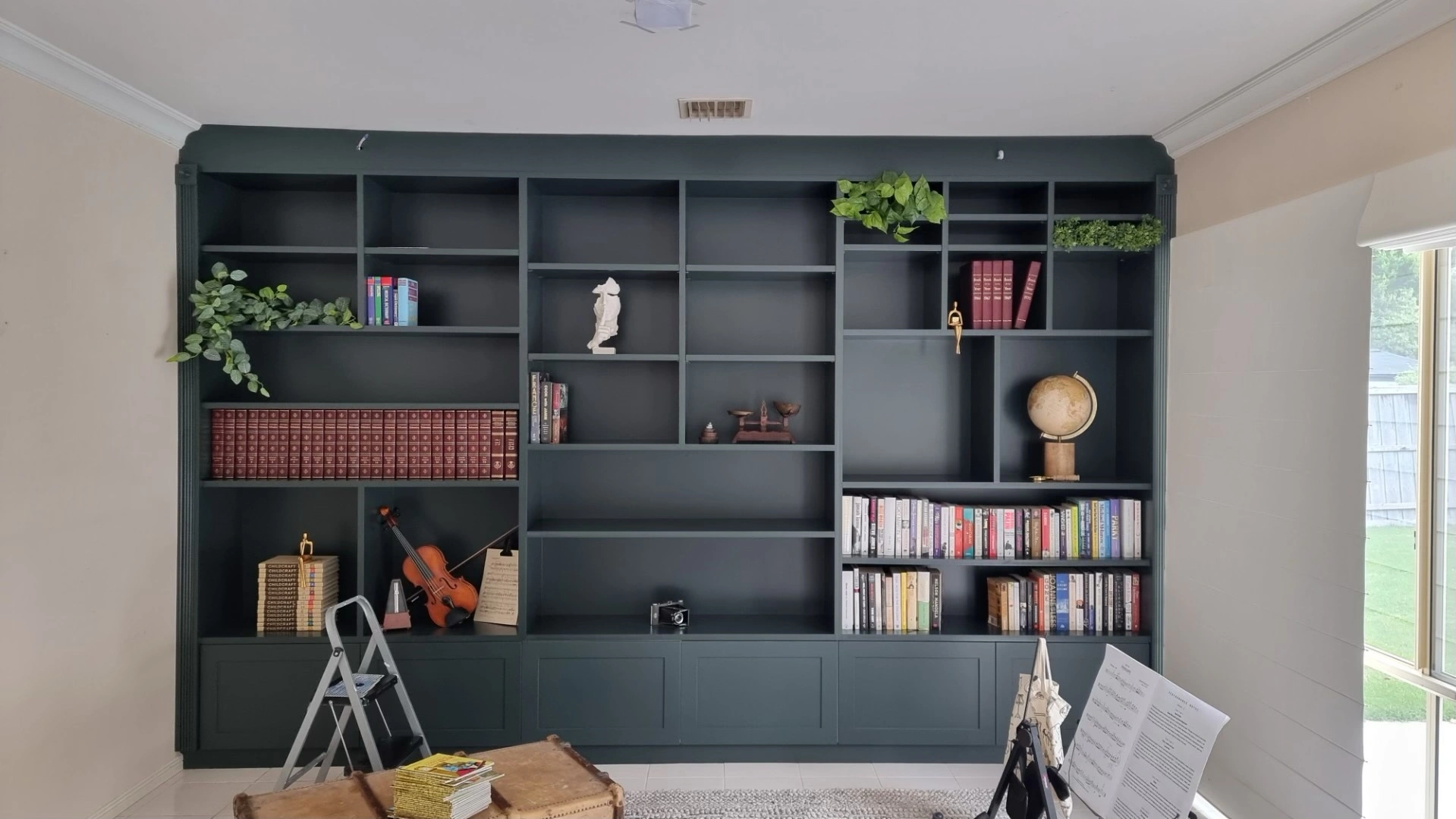 design-perfect-built-in-entertainment-unit.jpg Modern custom built in entertainment unit with open shelving, and a mounted flat-screen TV in a contemporary living room.